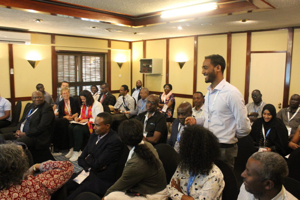 Man standing in a room with other professionals at the COECSA 2024 congress.