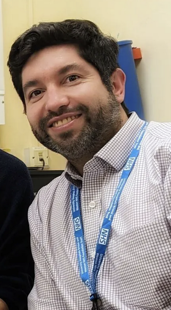 Four professionals wearing badges in front of a screen at a conference