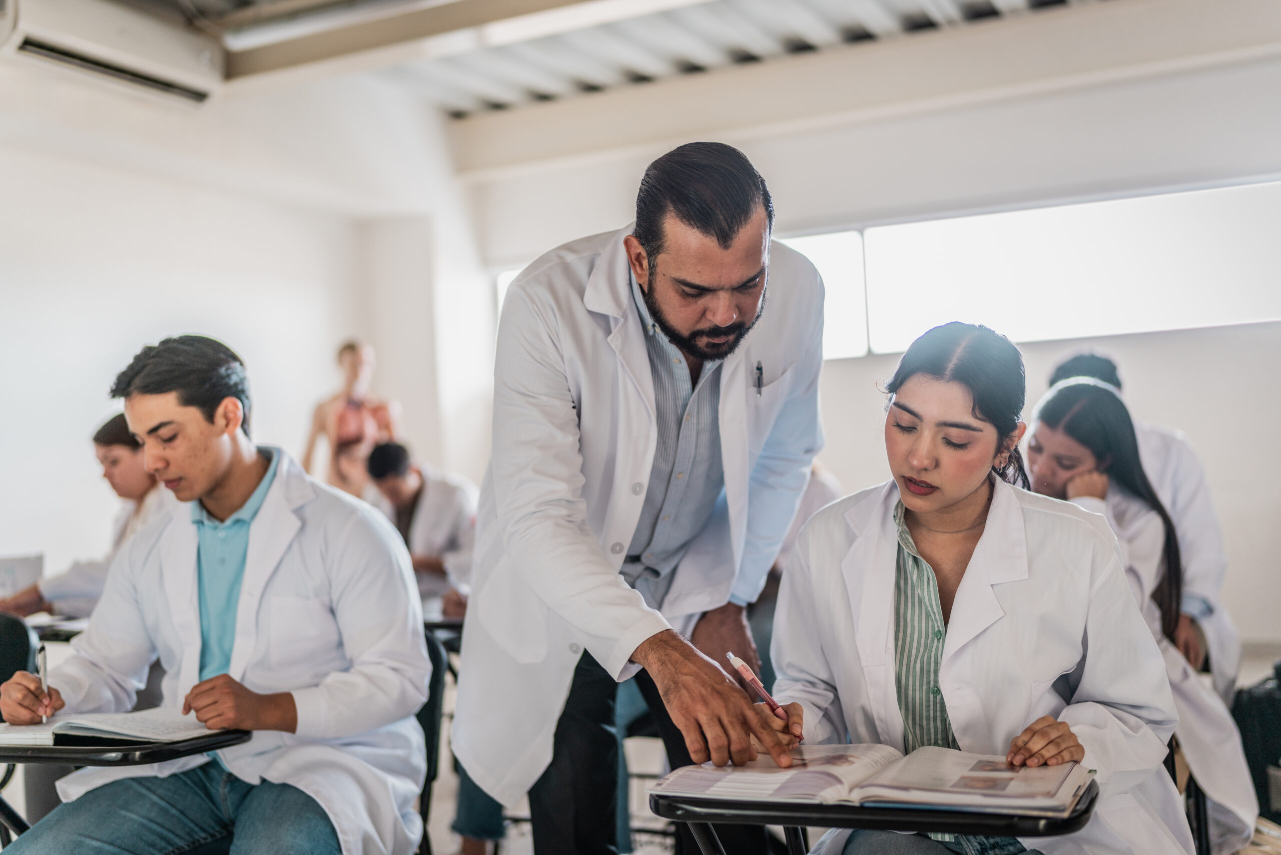 Mature medical professor helping student during  class at university