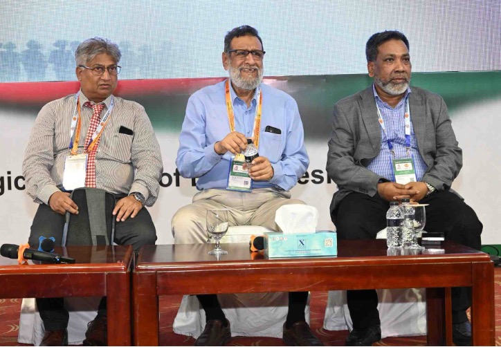 Four men standing in front of a screen at a conference in Bangladesh