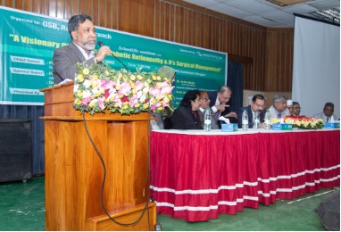 Four men standing in front of a screen at a conference in Bangladesh