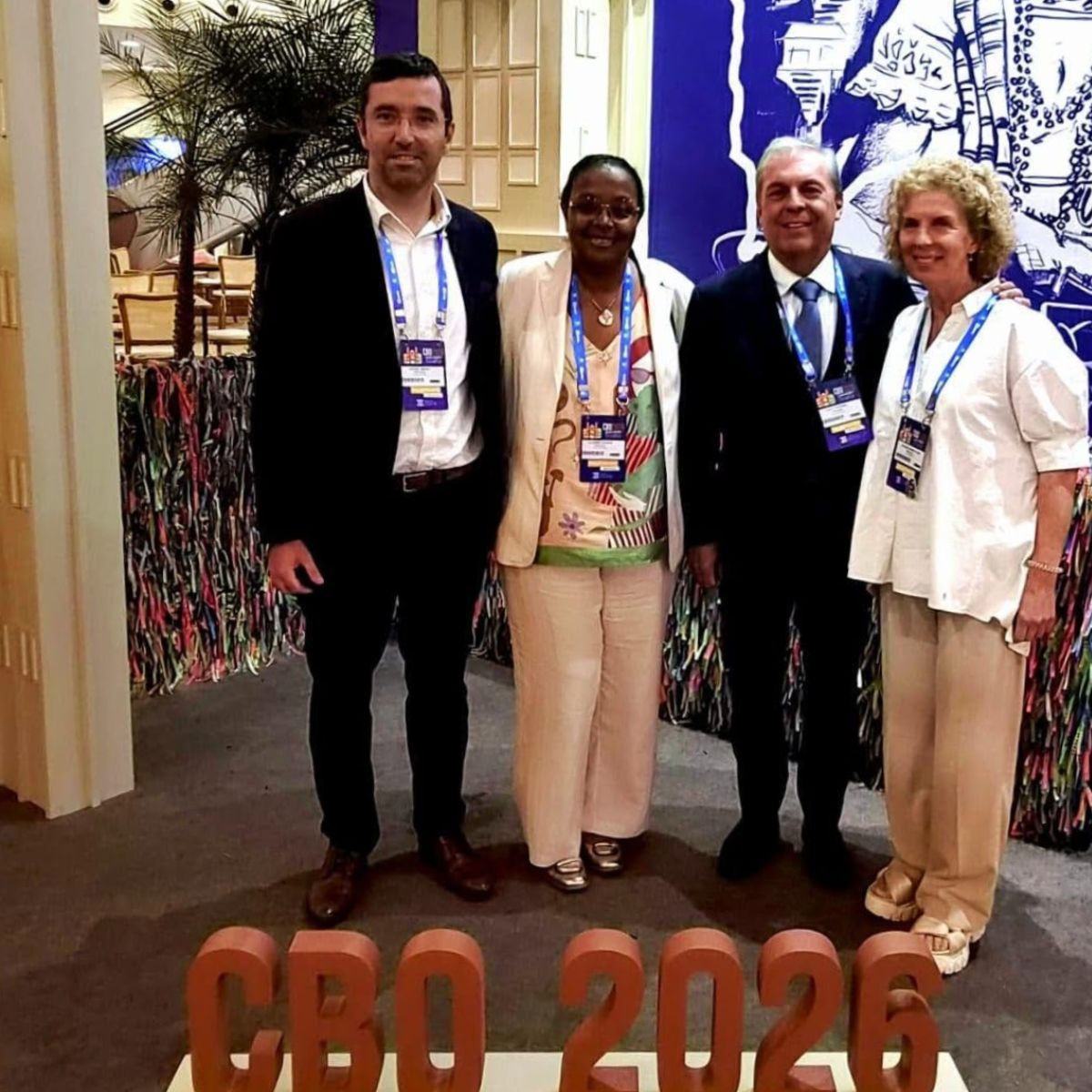 Four professionals at the Brazilian Ophthalmology Congress with a CBO 2026 sign